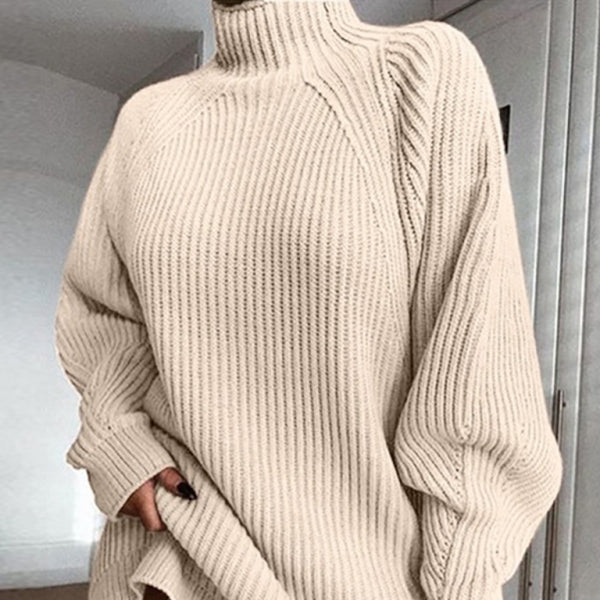 A mid-length beige turtleneck sweater dress with raglan sleeves, pictured against a neutral background.