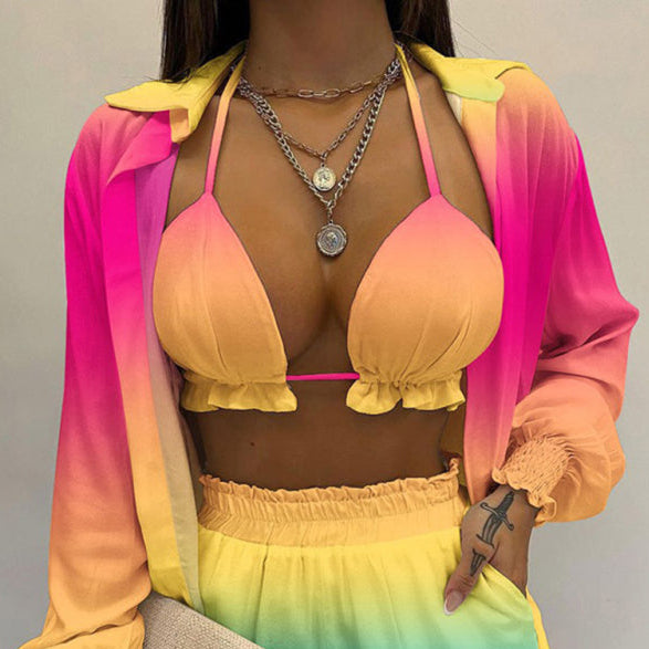 A model wearing a white long-sleeved shirt and matching shorts with a tropical print, paired with a white crop top.