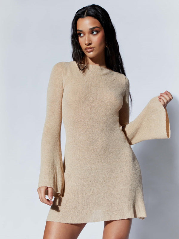 A woman wearing a beige backless knitted dress with bell sleeves and a slim fit.