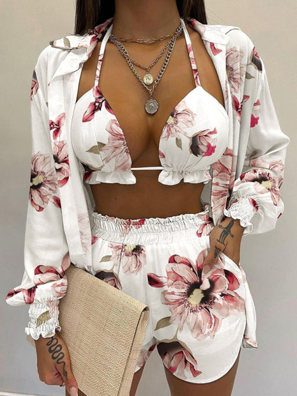 A model wearing a white long-sleeved shirt and matching shorts with a tropical print, paired with a white crop top.